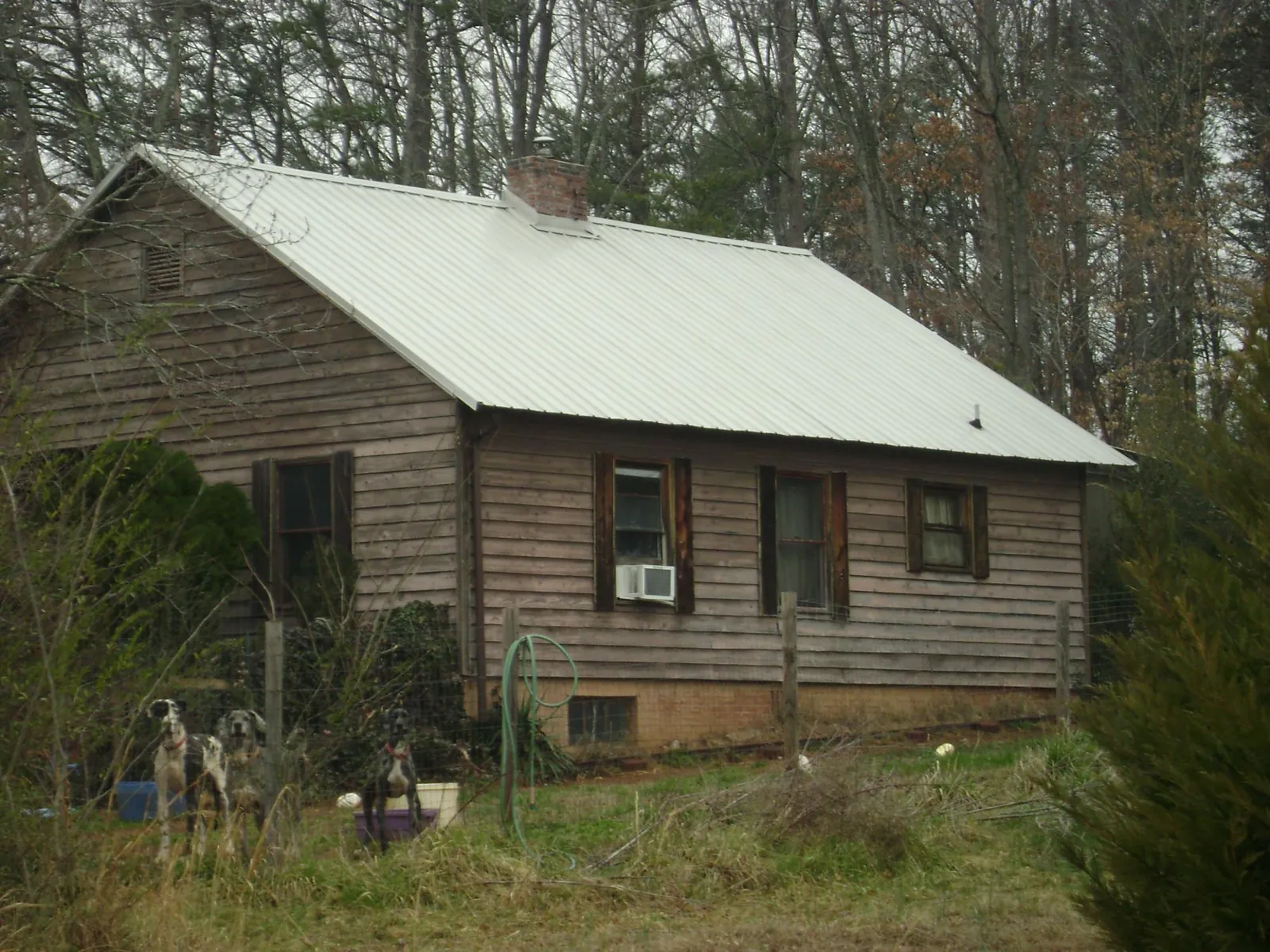 White metal roof on an old wood sided farmhouse, from a Metal Roof Installation job in Barney
